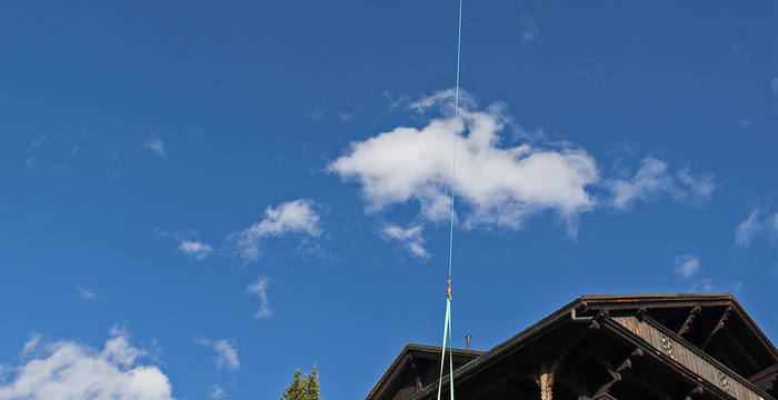 21.9.19 - Damit das Aussenregister der neuen Heizung an seinem Platz montiert werden kann, ist ein Flug mit dem Helikopter und viel Fingerspitzengefühl notwendig.